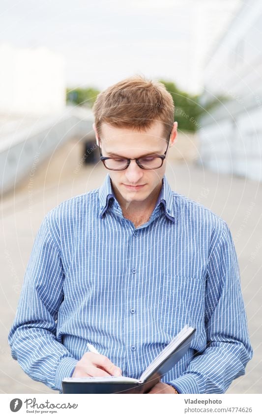 Führen Sie Interviews mit männlichen Journalisten und machen Sie sich Notizen in einem Notizbuch. professionell jung Business Büro Geschäftsmann Buch