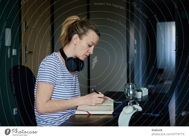 Frau arbeitet im Home Office mit Laptop heimwärts Büro Arbeit abgelegen Arbeitsplatz Freiberufler Business beschäftigt Überarbeitung Tisch Wasser Glas Pflanze