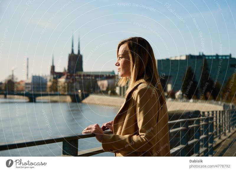 Fröhliche Frau spaziert auf der Straße der Stadt Europa Großstadt Spaziergang Tourist sonnig Tourismus selbstbewusst Tag Graben Mantel laufen Business stylisch