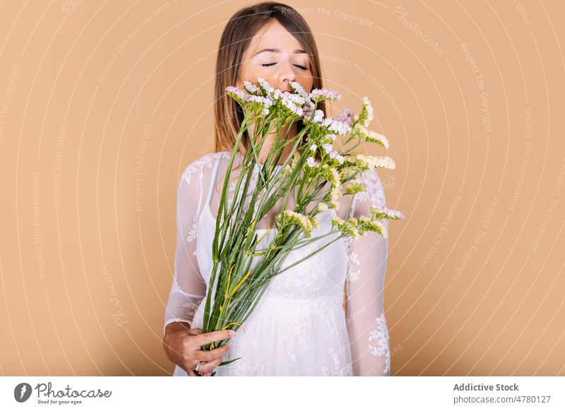 Braut im Kleid an Blumen riechend Frau weißes Kleid Hochzeit Stil Anlass Blumenstrauß geblümt Veranstaltung Augen geschlossen elegant Pflanze präsentieren