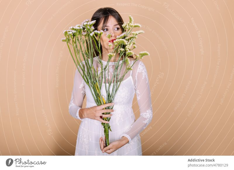 Braut im Kleid an Blumen riechend Frau weißes Kleid Hochzeit Stil Anlass Blumenstrauß geblümt Veranstaltung elegant Pflanze präsentieren duftig Aroma Feiertag