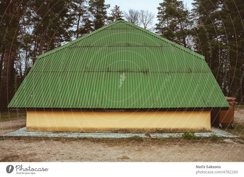 Gebäude mit gelber Wand und niedrigem Gründach Architektur Versammlung Dachboden Hintergrund blau braun Burgunder Belag Konstruktion gewellt Design Abfluss