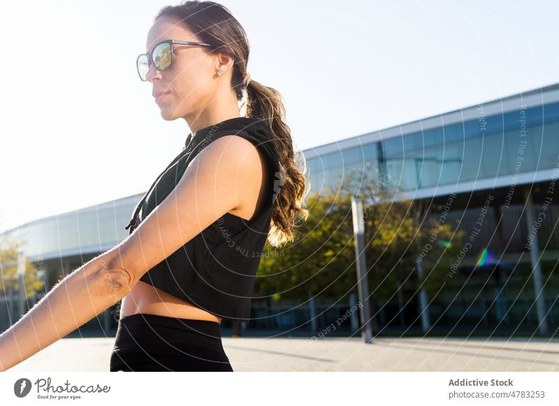 Sportlerin mit Sonnenbrille auf der Straße stehend Training Pause ausrichten Athlet pausieren Gesunder Lebensstil Sportkleidung sportlich Wohlbefinden Großstadt