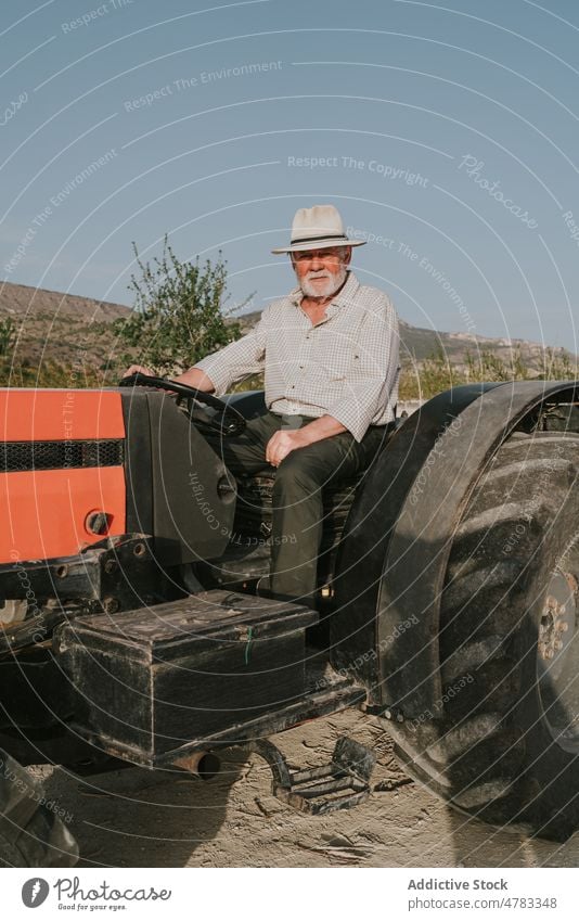 Mann auf Traktor im Obstgarten industriell Baum Landwirt Aprikose Schonung Landschaft Industrie Blütezeit kultivieren Garten Ackerbau Flora Verkehr Pflanze