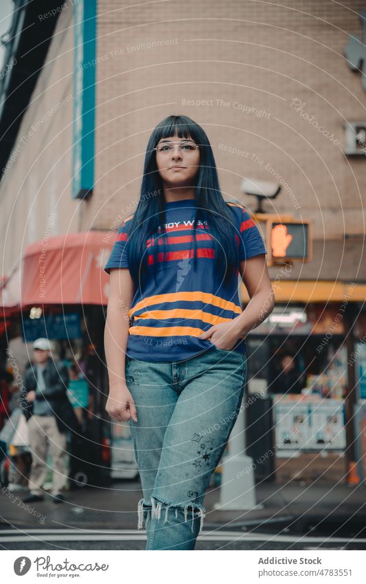 Frau steht auf der Straße in der Nähe eines Gebäudes Großstadt Stil Outfit urban Vorschein trendy Hand-in-Tasche Sommer Brille selbstbewusst Stadt jung Dame