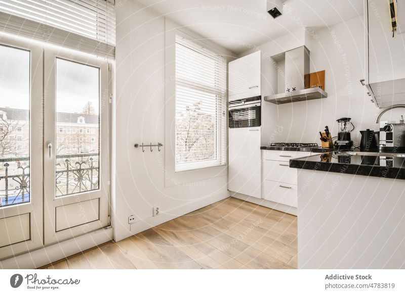 Interieur einer modernen weißen Küche Innenbereich Design Stil Abfertigungsschalter Küchengeräte Vorrichtung Fenster Appartement flach heimwärts Waschbecken