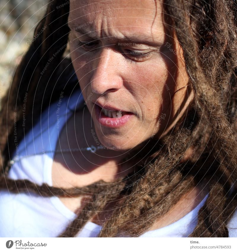 Frau, konzentriert frau portrait locken rastas t-shirt halskette ersnt sonnig halbschatten Stirnfalte aufmerksam beschäftigt fokussiert