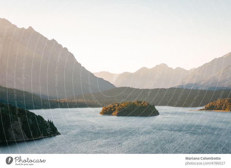 Blick auf einen See, eine Insel, Berge und Bäume bei Sonnenuntergang Landschaft Natur Sonnenlicht Klarer Himmel ruhig Abenddämmerung Außenaufnahme Licht