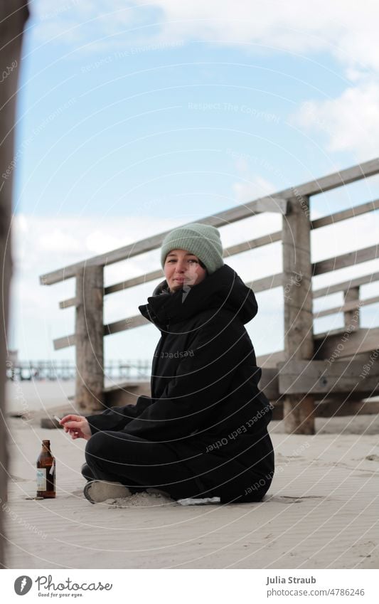 Frühling am Meer Meereslandschaft Strand Sand Sandstrand kalt Mütze Mantel schwarz Wolken Himmel weite Steg Holzsteg Nordsee Norden nordisch Bier Zigarette