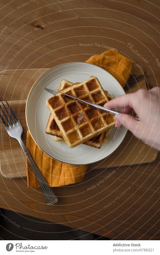 Anonyme Person isst leckere Waffeln, die auf einem Keramikteller serviert werden Dessert dienen süß selbstgemacht Lebensmittel gebacken kulinarisch Teller