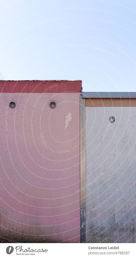 Verwitterte Rückansicht zweier Garagen in rosa und weiß mit Himmel. Wand Mauer Haus Gebäude Architektur trist grau alt Lüftungsklappe Menschenleer