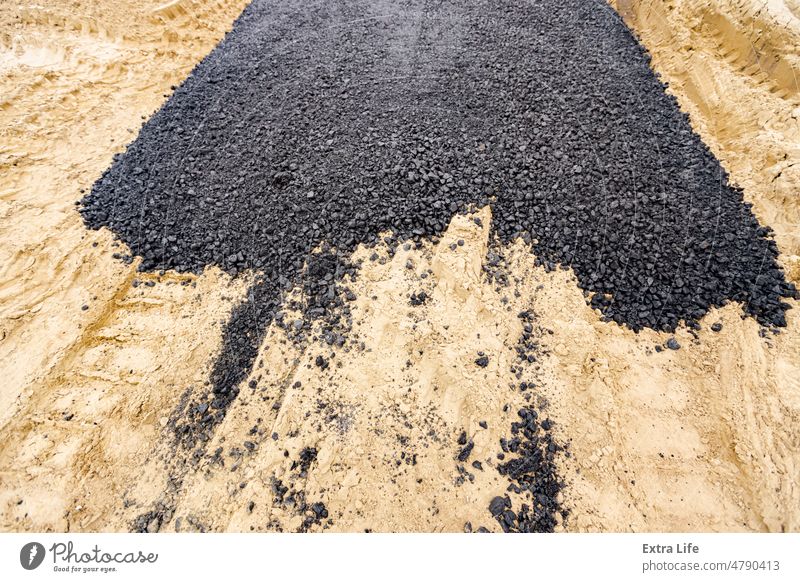 Eine Schicht aus frischem und heißem Asphalt auf dem Sand abstrakt Asphaltierung Hintergrund Bitumen schwarz braun Ton abschließen Beton Konstruktion dunkel