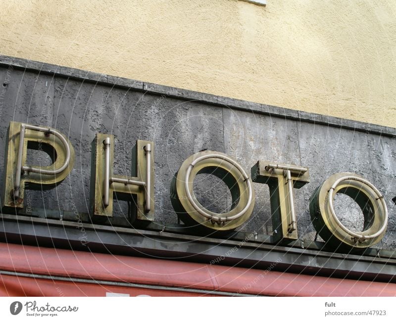 Photo Fotografie Leuchtstoffröhre Neonlicht Buchstaben gelb Fotogeschäft Haus Gebäude Wand retro Werbung Leuchtreklame Dinge Putz Beton grau Schriftzeichen