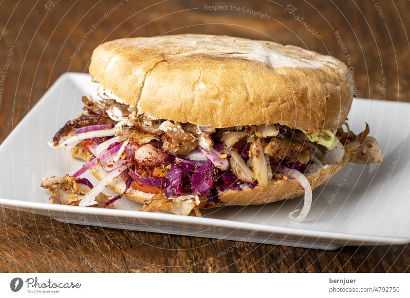 Döner Kebap auf Holz döner kebab Teller Holztisch weiß Blaukraut Rotkohl Giros gyros Zwiebel Pita Brot Fastfood deftig rustikal Salat tsatsiki soße