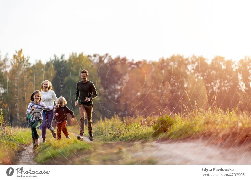 Junge Familie hat Spaß im Freien laufen rennen Blatt Natur Feld Park Herbst fallen Mann Papa Vater Frau Mutter Eltern Verwandte Sohn Kinder Partnerschaft