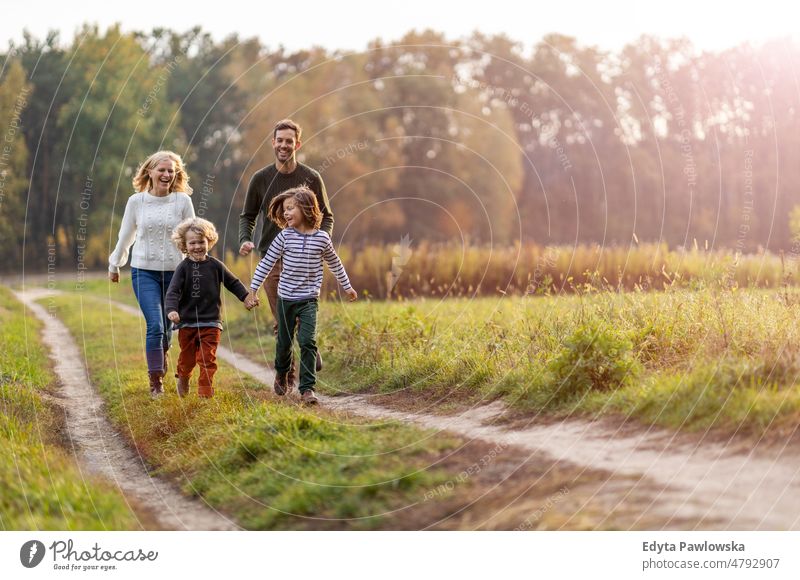 Junge Familie hat Spaß im Freien laufen rennen Blatt Natur Feld Park Herbst fallen Mann Papa Vater Frau Mutter Eltern Verwandte Sohn Kinder Partnerschaft