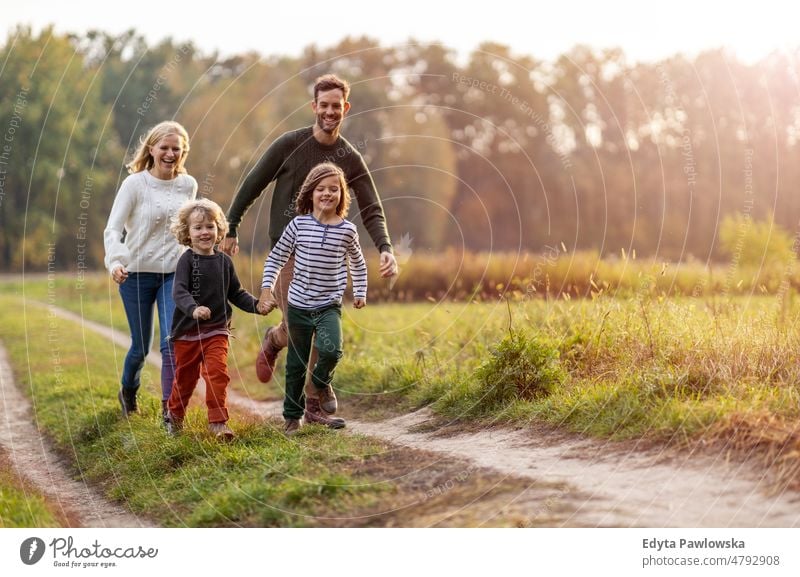 Junge Familie hat Spaß im Freien laufen rennen Blatt Natur Feld Park Herbst fallen Mann Papa Vater Frau Mutter Eltern Verwandte Sohn Kinder Partnerschaft