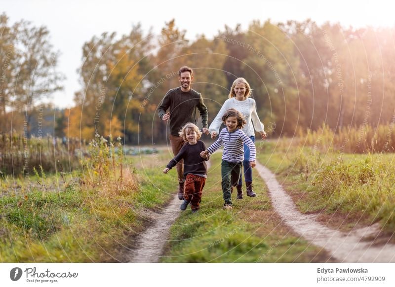 Junge Familie hat Spaß im Freien laufen rennen Blatt Natur Feld Park Herbst fallen Mann Papa Vater Frau Mutter Eltern Verwandte Sohn Kinder Partnerschaft