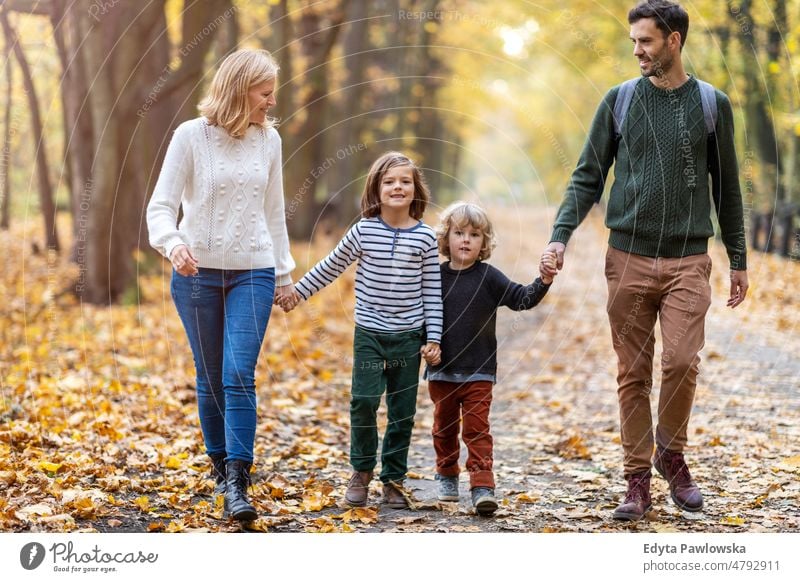 Eltern mit Kindern bei einem Spaziergang im Park laufen rennen Blatt Natur Feld Herbst fallen Mann Papa Vater Frau Mutter Familie Verwandte Sohn Junge