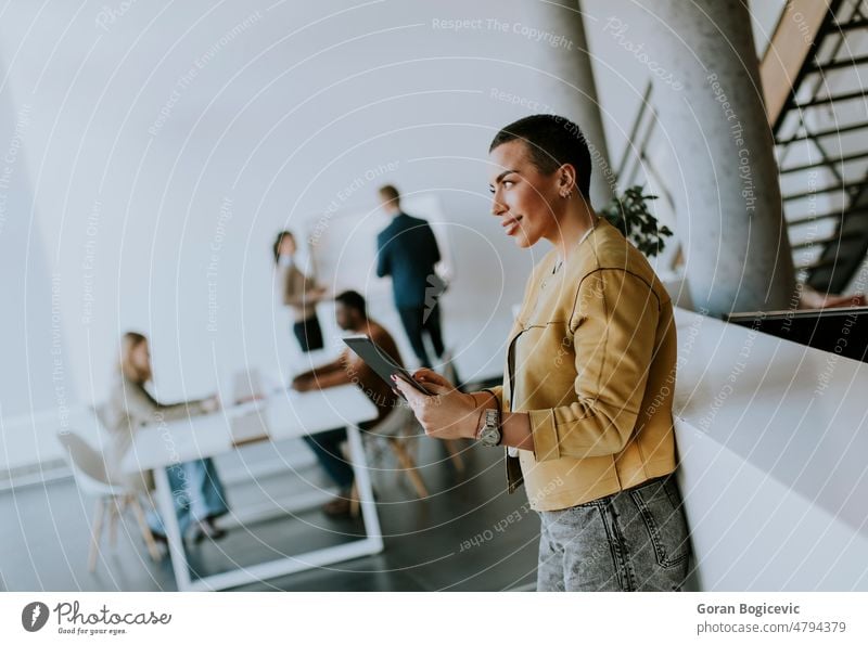 Junge kurzhaarige Geschäftsfrau, die im Büro steht und vor ihrem Team ein digitales Tablet benutzt Manager Erwachsener attraktiv Business Karriere Kaukasier