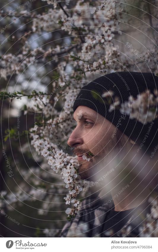 Männerporträt unter einem blühenden Pflaumenbaum Mann Porträt Vollbart Porträtfotografie Pflaumenblüte Blütenblätter schwarzer Hut Bartiger Mann Seitenprofil