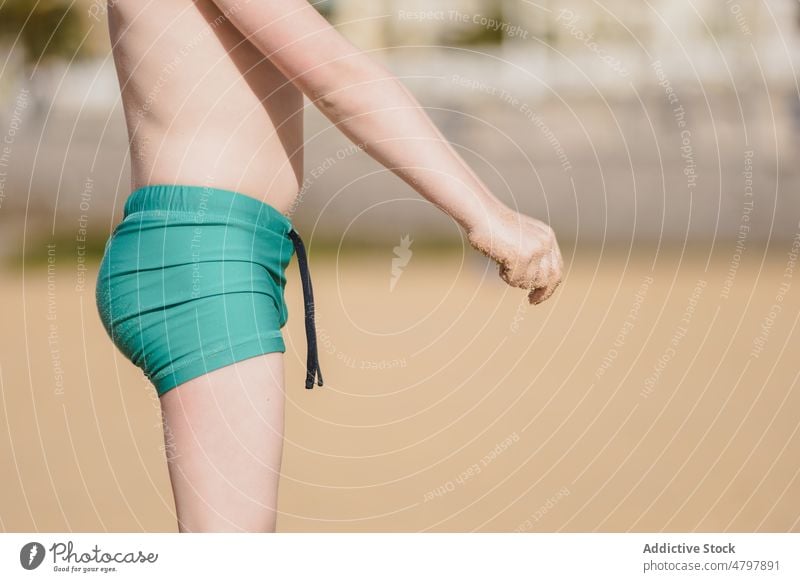 Unbekannter Junge in Badekleidung am Strand Kind Badebekleidung Sommer Küste Kindheit ruhen Erholung Ufer nackter Torso ohne Hemd Zeitvertreib Shorts Freizeit