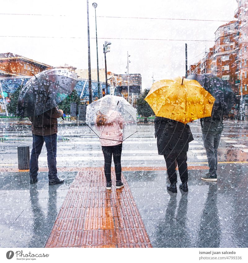 Menschen mit einem Regenschirm an regnerischen Tagen Person regnet Regentag Wasser menschlich Fußgänger Straße Großstadt urban Bilbao Spanien laufen Lifestyle