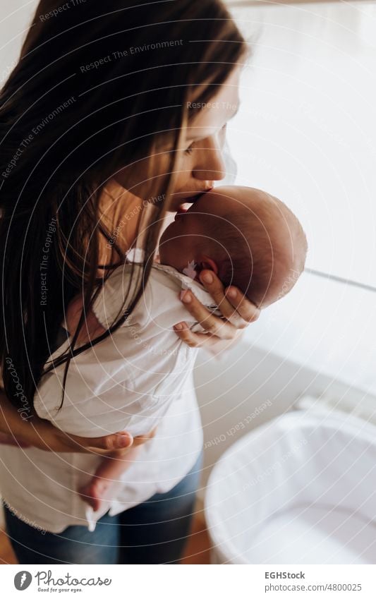 Close up junge Mutter küsst neugeborenes Baby auf die Stirn abschließen Küssen Mama Frau Kuss newbbaby Kind Person Familie Pflege Kindheit Liebe Beteiligung