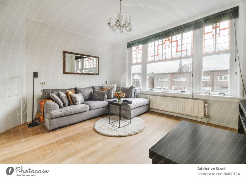 Wohnzimmer mit Couch und Fenster Innenbereich Design Stil stylisch modern Dekor Liege Appartement Sofa heimwärts geräumig Licht Möbel verweilen flach Sitz