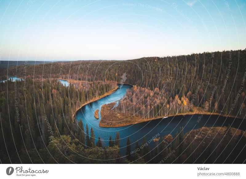 Biegung des Kitkajoki-Flusses im Oulanka-Nationalpark in Nordfinnland bei Sonnenuntergang. Herbstlicher Fichtenwald mit blauem Fluss, der eine Schlange bildet. Suomi Natur