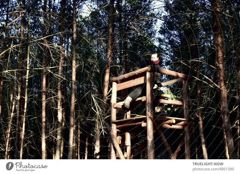 Suchbild mit Dame | Auf Hochsitz im Kiefernwald bei Sonnenschein und ganz allein hat sie es sich mit leuchtendem Gesicht gemütlich gemacht und lässt die dicken Schuhe an den Füßen einfach raushängen