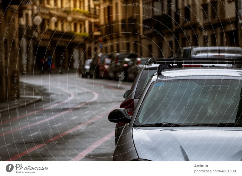 Reihe von Autos geparkt entlang der Straße und alte Gebäude in Europa Stadt. Viele Autos geparkt auf der Straße in der alten Stadt. Stadt Straße in Europa. Frontansicht von Auto geparkt außerhalb Wohngebäude. Stadtverkehr.