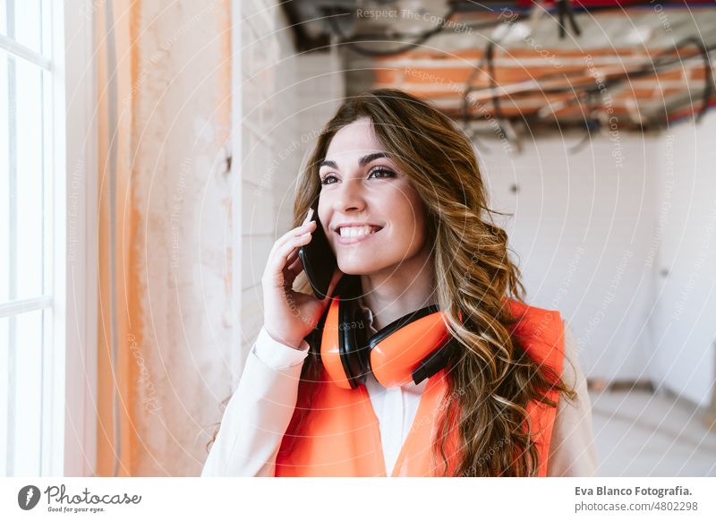 Inspektor oder Architektin auf der Baustelle, die mit dem Handy telefoniert. Küche Frau Überprüfung heimwärts Laptop unkenntlich Blaupausen Arbeitsbereich