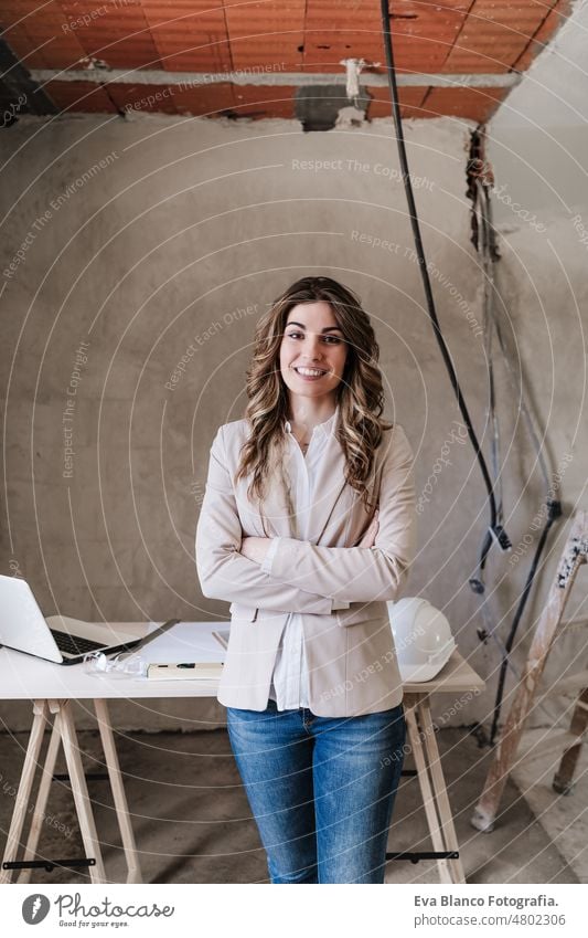 professionelle selbstbewusste Architektin auf der Baustelle. Haus Renovierung Frau Blaupausen Arbeitsbereich Schutzhelm Schutzmantel Handy Grundbesitz Kaukasier