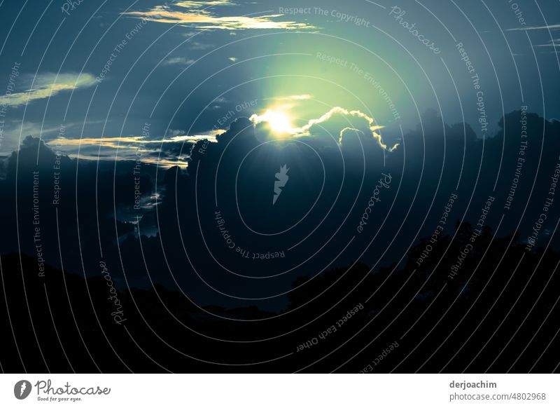 Der Himmel verdunkelt sich. Wolken Berge türmen sich auf. Die Sonne verschwindet fast dahinter. Untergang Außenaufnahme Kontrast Natur Farbfoto Schatten Umwelt