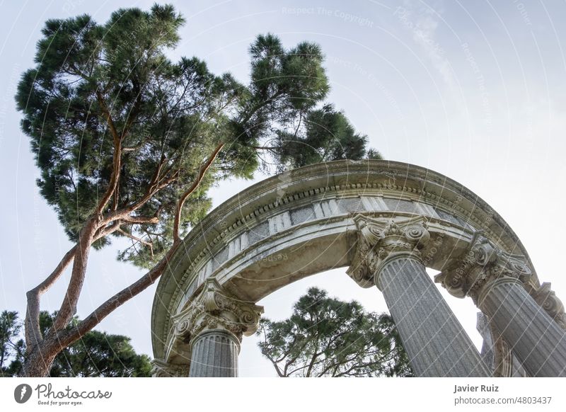 Tempel, Pavillon oder Kolonnade mit hohen Bäumen im Hintergrund, Säulen mit verzierten Kapitellen, Park El Capricho, Alameda de Osuna Madrid templete Spalten