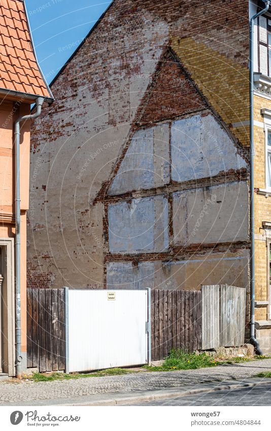 Mut zur Lücke lückenhaft Baulücke Giebelseite Abdruck Haus Wand Gebäude Menschenleer Außenaufnahme Farbfoto Architektur Stadt Bretterzaun Ausfahrt freihalten