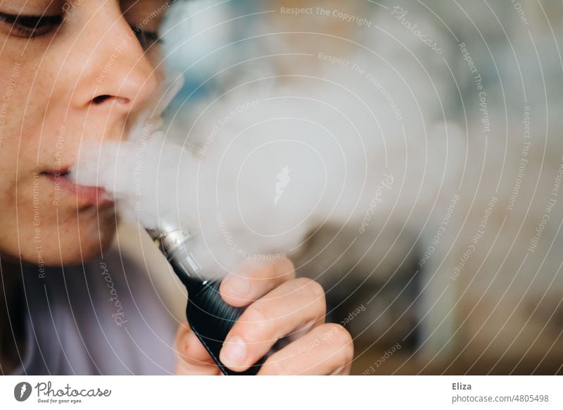 Frau dampft eine E-Zigarette, als Alternative zum Rauchen dampfen Verdampfer Vaping Rauchentwöhnung Raucherin Nikotin elektrisch Dampf elektronische Zigarette