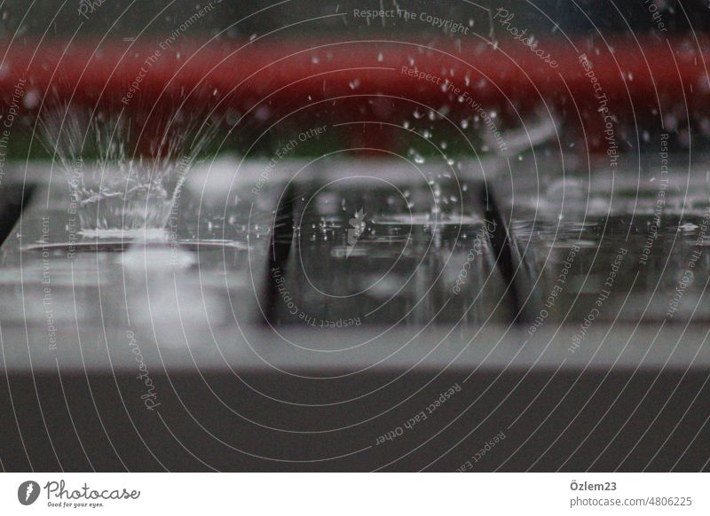 Regentropfen, die auf den Tisch plätschern platschen Natur Wetter nass Außenaufnahme Tropfen