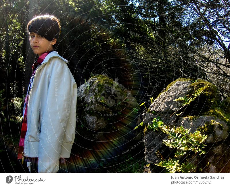 Porträt mit Regenbogen-Lichteffekt, eines Jungen, der auf den Zinnen des Castelo dos Mouros in Sintra, Lissabon, Portugal, posiert. Kind Burg oder Schloss