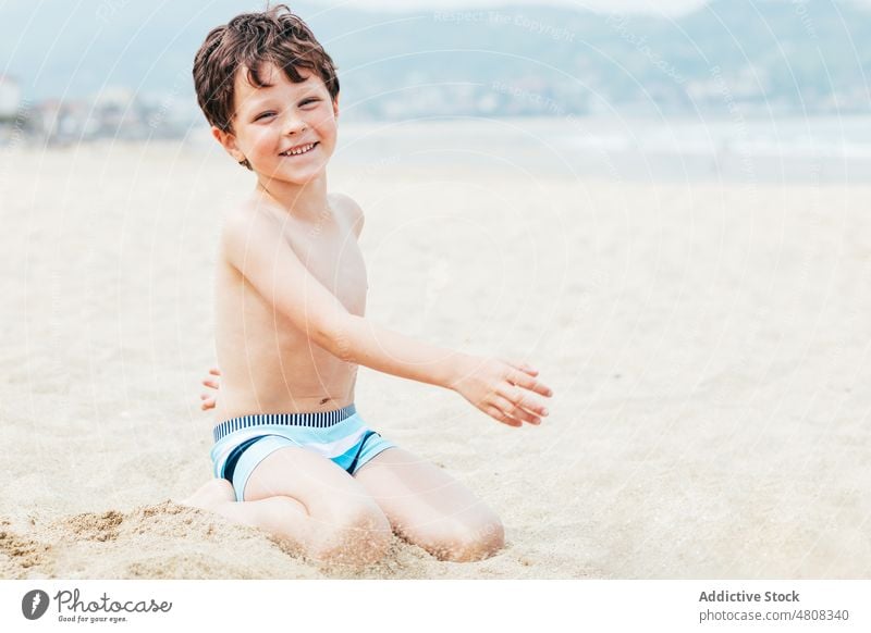 Junge schaut in die Kamera am Strand ruhen Wochenende Sommer Urlaub Lächeln Porträt Resort Kind tagsüber niedlich Kindheit Ufer sich[Akk] entspannen bezaubernd