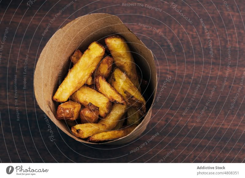 Leckere Pommes frites in Papiertüte Zapfen Restaurant zum Mitnehmen Paket Fastfood Kartoffel dienen Portion appetitlich Junk Food Gastronomie Tisch köstlich