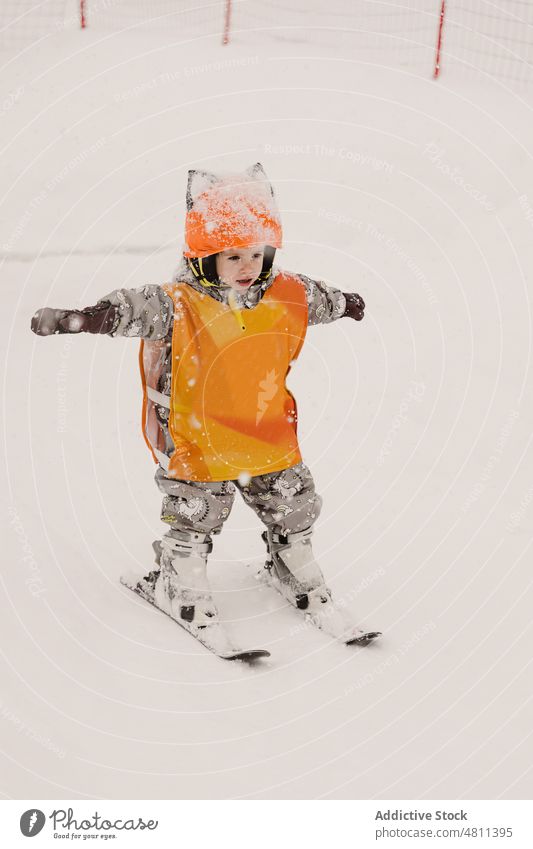 Niedliches Kind übt Skifahren an einem Wintertag üben Skigebiet Schnee Training Aktivität Sport aktiv Skifahrer Mädchen Schutzhelm Mut Kleinkind Oberbekleidung