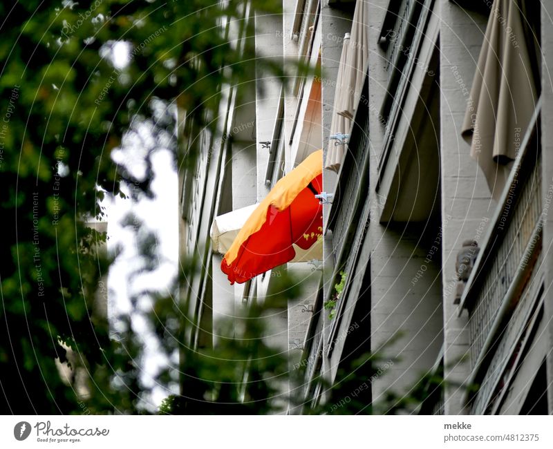 [hansa BER 2022] Sonniger Sonnenschirm in grauer Fassade Wohnhaus Haus Stadt mietshaus wohngebiet mehrfamilienhaus wohnen innenstadt Neubau Balkon Etage Etagen