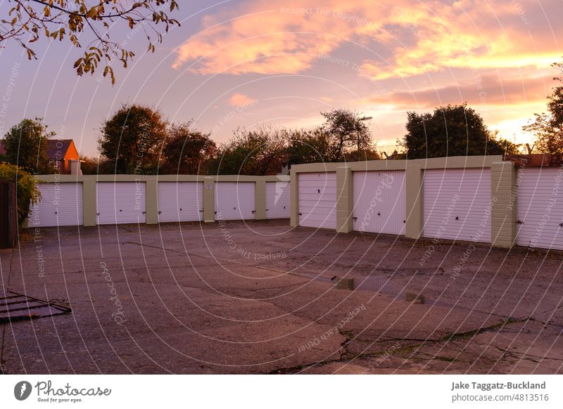 Malerische britische Garagen vor wunderschönem gold-rosa Sonnenuntergang und Bäumen parken Briten golden Haus Seeküste Urlaub Sommer MEER Himmel Strandhaus Sand