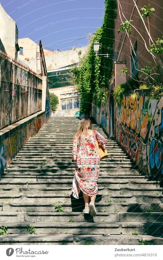 Frau im bunten Kleid auf einer baufälligen Treppe in Cagliari aufsteigen Aufstieg Stufen Treppen Treppenstufen alt aufwärts Treppengeländer Urlaub Sardinien