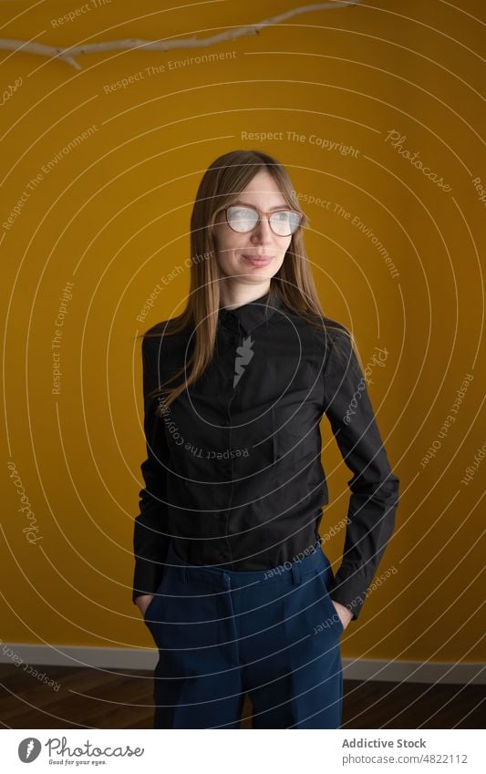 Frau in eleganter Freizeitkleidung schaut weg smart lässig heimwärts Vorschein Porträt verträumt hell Stil Brille Erwachsener Zeitgenosse lebhaft Accessoire