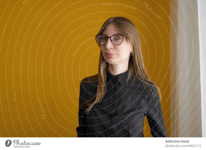 Frau in eleganter Freizeitkleidung schaut in die Kamera smart lässig heimwärts Vorschein Porträt verträumt hell Stil Brille Erwachsener Zeitgenosse lebhaft