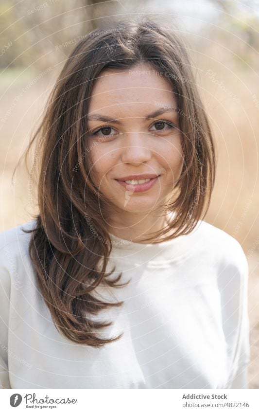 Ruhige Frau steht in ländlicher Umgebung und schaut in die Kamera Wiese selbstbewusst Natur Landschaft Model Stil Porträt feminin Windstille Vorschein Feld jung