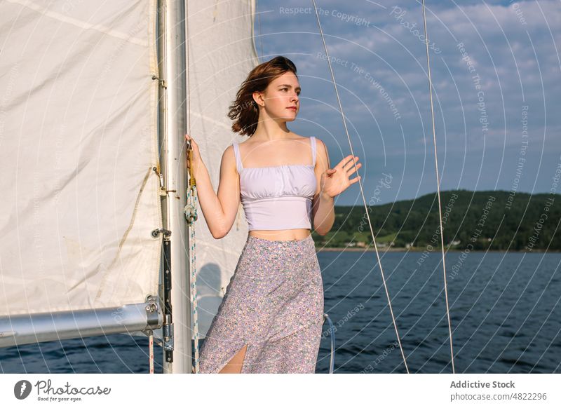 Ruhige junge Frau bewundert die Natur, während sie auf einem Segelboot steht MEER Jacht bewundern Feiertag Kreuzfahrt Sommer Urlaub Porträt trendy Stil Ausflug